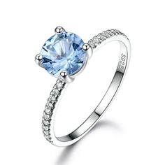 The Created Sky Blue Topaz Engagement Ring from the Ginger Lyne Collection is a testament to timeless elegance and contemporary design. This stunning ring features a lab-created sky blue topaz, boasting a serene 7mm stone that captures the essence of a tranquil sky. The vibrant blue of the topaz is beautifully contrasted with the sparkling clarity of AAA quality cubic zirconia accents, creating a captivating display of color and brilliance. Crafted with .925 sterling silver, this ring benefits f Sky Blue Topaz Engagement Ring, Gemstone Wedding, Topaz Birthstone, Blue Topaz Engagement Ring, Topaz Engagement Ring, Blue Topaz Stone, January 23, Sky Blue Topaz, Square Rings