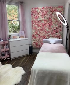 a bed room with a neatly made bed next to a window and a flower covered wall