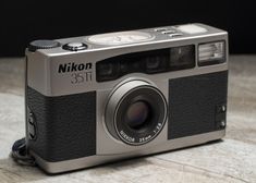 a silver and black camera sitting on top of a table