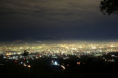 the city lights shine brightly in the dark night sky over a large area of land