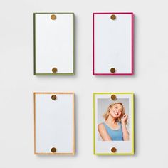 four different colored frames hanging on the wall with photos attached to them, one has a woman's face and two are holding a cell phone