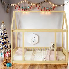 there is a bed with a canopy and lights on the wall above it, next to a christmas tree