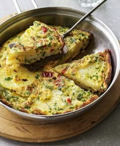 a pan filled with food on top of a wooden cutting board