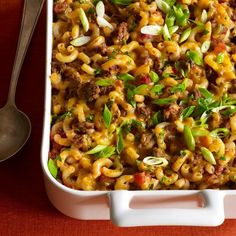 a casserole dish with meat and vegetables in it on a red tablecloth