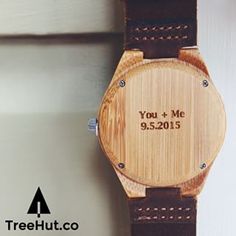 a wooden watch with the date you and me engraved on it's leather strap