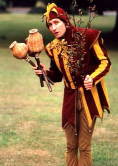 a man dressed in costume holding some plants