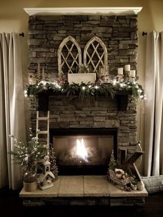 a living room with a fire place in the center and flowers on the mantel