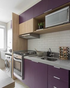 a kitchen with purple cabinets and stainless steel appliances, along with a white counter top