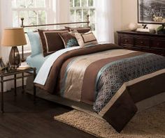 a bed with brown and blue comforters in a bedroom