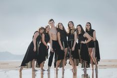 a group of people standing next to each other on a beach