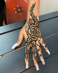 a woman's hand with hendix on it and flowers painted on the palm