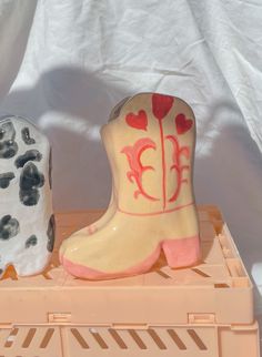 two ceramic cowboy boots sitting on top of each other