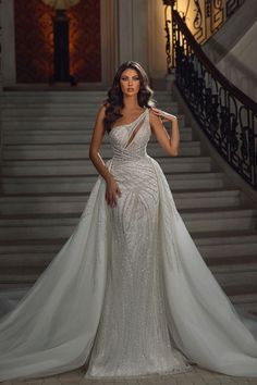 a woman in a wedding dress standing on stairs