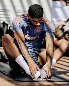 a man sitting on the ground tying his shoes