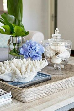 a coffee table topped with a vase filled with blue flowers