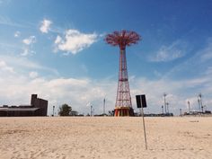 a red radio tower sitting on top of a sandy beach