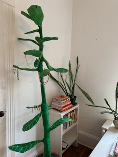 a tall green plant sitting on top of a wooden table next to a white door