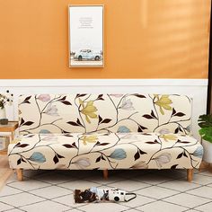 a white couch sitting on top of a tiled floor next to a potted plant