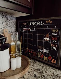 a kitchen counter with a chalkboard and two bottles on it next to utensils