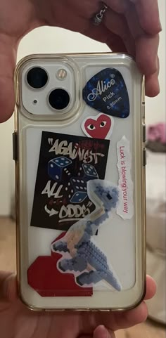 someone is holding up their phone case with stickers on it and there are other things in the case