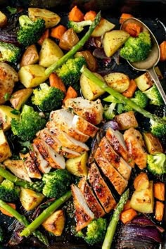 chicken, potatoes and broccoli in a pan with spoons on the side