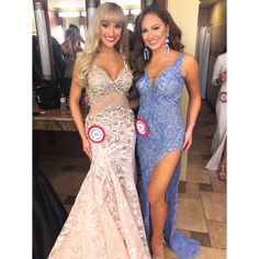 two beautiful women standing next to each other in front of a mirror wearing evening gowns