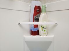 the bathroom shelf is holding two bottles of shampoo and lotion