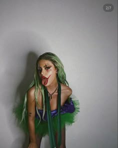 a woman with green hair and makeup is posing for the camera while wearing a costume