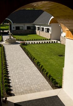 an open door leading to a house with a lawn and stone walkway in the foreground