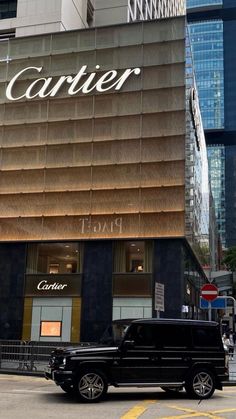 a black truck is parked in front of a cartier store