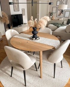 a dining room table with chairs and a rug on the floor in front of it