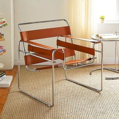 an orange chair sitting on top of a carpeted floor next to a table and bookshelf