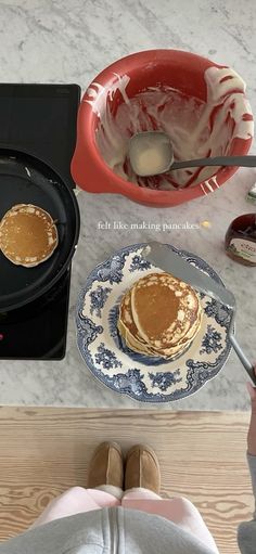 pancakes being cooked in a cast iron skillet on top of a stove with butter and syrup