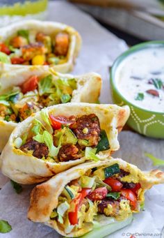 three burritos filled with meat and veggies next to a bowl of yogurt