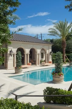 an outdoor swimming pool surrounded by trees and shrubs