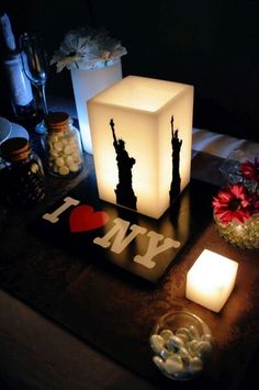 a lit candle and some flowers on a table