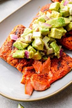 salmon with avocado and red onions on a plate