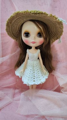 a doll wearing a straw hat and dress