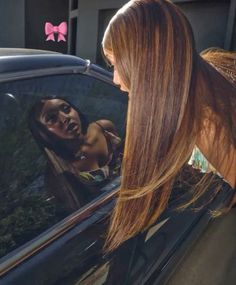 a woman sticking her head out the window of a car with an ad on it