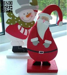 santa and mrs claus standing next to each other in front of a window with qr code on it