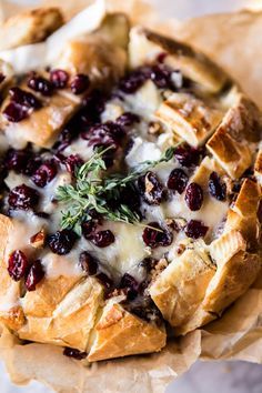 cranberry bread with cheese and herbs in it on top of brown parchment paper