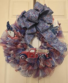 a patriotic wreath with an old truck and snowman on it, hanging from the front door