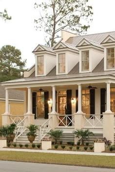 a large white house with lots of windows and porches on the side of it