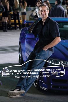 a man sitting on the hood of a blue car