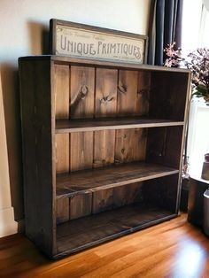 an old fashioned wooden bookcase sitting on top of a hard wood floor next to a potted plant