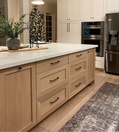 a large kitchen with an island in the middle and lots of cabinets on both sides