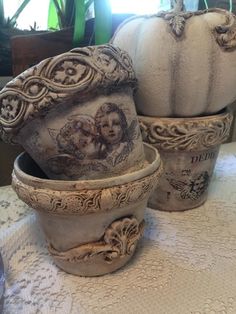 two white pumpkins sitting on top of a table next to other decorative dishes and vases