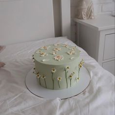 a cake with daisies on it sitting on a bed