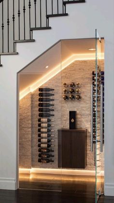 a wine cellar in the middle of a room with stairs leading up to an upper level