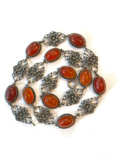 Antique Carnelian Sterling Silver Filigree Necklace Vintage Victorian Italian Cannetille Cornelian 15.5" Choker Edwardian Estate Jewelry Offered here is a charming sterling silver Victorian Italian necklace featuring beautiful filigree and ten carnelian stones.  Cannetille is a close relative of filigree work. It typically features fine gold wires or thinly hammered sheets. Jewelry with cannetille was very popular in the 1820's and 1830's. Motifs included tendrils, scrolls, coils, beehives and spider-like rosette ornaments. Age: circa 1900-1910 Measurements:  The necklace - choker weighs 19 grams.  It is 15 1/2 inches long.  The 10 carnelian stones are 1/2 inch by 3/8 inch ovals.   Condition:  It is in overall very good condition, consistent with age. There is no damage only light wear exp Rosette Ornaments, Italian Necklace, Filigree Necklaces, Modernist Design, Sterling Silver Filigree, Vintage Victorian, Vintage Vogue, Necklace Choker, Victorian Jewelry